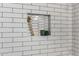 Modern shower niche with hexagon tile and wooden shelf at 1014 E Michigan Ave, Phoenix, AZ 85022