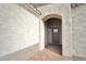 Front entry with arched entryway and gray door at 14595 S Vera Cruz Rd, Arizona City, AZ 85123