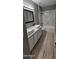Updated bathroom with double vanity, marble shower, and modern flooring at 17913 W Desert View Ln, Goodyear, AZ 85338