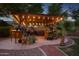 Outdoor patio with pergola, string lights and lush plants at 2592 E San Rafael Trl, Casa Grande, AZ 85194