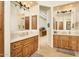 Double vanity bathroom with wood cabinets and a large mirror at 10803 E La Junta Rd, Scottsdale, AZ 85255