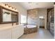 Luxurious bathroom with soaking tub, walk-in shower, and modern vanity at 21391 E Orchard Ln, Queen Creek, AZ 85142