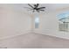 Spacious bedroom with two windows and ceiling fan at 38124 W Santa Barbara Ave, Maricopa, AZ 85138