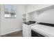 Laundry room with washer, dryer, and shelving at 38124 W Santa Barbara Ave, Maricopa, AZ 85138