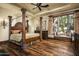 Elegant bedroom with a large four-poster bed and hardwood floors at 11068 E Canyon Cross Way, Scottsdale, AZ 85255
