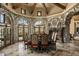 Elegant dining room with stone walls, arched windows, and a large table at 11068 E Canyon Cross Way, Scottsdale, AZ 85255