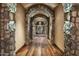 Stone hallway with arched entryways and hardwood floors at 11068 E Canyon Cross Way, Scottsdale, AZ 85255