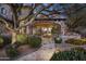 Evening view of stone patio, landscaping, and lighting at 11068 E Canyon Cross Way, Scottsdale, AZ 85255