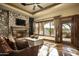 Cozy living room with stone fireplace and access to patio at 11068 E Canyon Cross Way, Scottsdale, AZ 85255