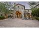 Stone manor house with arched entryway and landscaping at 11068 E Canyon Cross Way, Scottsdale, AZ 85255