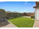 Landscaped backyard with artificial turf, patio, and string lights at 20865 E Timberline Rd, Queen Creek, AZ 85142