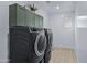 Laundry room with dark washer and dryer and upper cabinets at 20865 E Timberline Rd, Queen Creek, AZ 85142