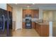Kitchen boasts wood cabinets, granite counters, and black appliances at 3214 N Desert Horizons Ln, Casa Grande, AZ 85122