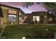 Landscaped backyard with artificial turf and lighting at 5630 E Rockridge Rd, Phoenix, AZ 85018