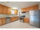Kitchen boasts wood cabinets, stainless steel appliances, and tiled floors at 1025 S Lola Ln, Tempe, AZ 85281