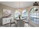 Virtually staged dining area with large windows and chandelier at 11806 N 40Th Pl, Phoenix, AZ 85028