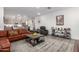 Living room with leather sofa, coffee table, and large TV at 1372 W Crane Dr, Chandler, AZ 85286