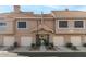 Tan two-story building with several units, featuring garages and landscaping at 1633 E Lakeside Dr # 113, Gilbert, AZ 85234