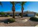 Single-story home with a landscaped front yard, two palm trees, and a two-car garage at 17827 N Conquistador Dr, Sun City West, AZ 85375