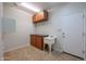 Laundry room with wooden cabinets and utility sink at 5124 W Gwen St, Laveen, AZ 85339