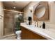 Modern bathroom with a walk-in shower, wood vanity, and gold fixtures at 5301 E Roadrunner Rd, Paradise Valley, AZ 85253
