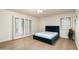 Bright bedroom with light wood floors, a teal upholstered bed, and white shutters at 5301 E Roadrunner Rd, Paradise Valley, AZ 85253