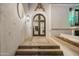 Elegant home with arched entryway, iron doors, and stone steps at 5301 E Roadrunner Rd, Paradise Valley, AZ 85253