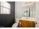 Small bathroom with wood vanity, toilet, and window at 9706 N 82Nd Gln, Peoria, AZ 85345