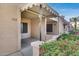Tan colored condo building with a covered patio and red flowers at 14300 W Bell Rd # 65, Surprise, AZ 85374