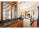 Dark granite countertop wet bar with wood cabinetry at 10432 E Winter Sun Dr, Scottsdale, AZ 85262
