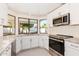 Modern white kitchen with granite countertops and stainless steel appliances at 1437 W Iris Dr, Gilbert, AZ 85233