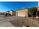 Two-car garage with desert landscaping, and a paved driveway at 18650 N 91St Ave # 4001, Peoria, AZ 85382