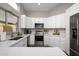 Modern kitchen with white cabinets, stainless steel appliances, and quartz countertops at 4636 E Danbury Rd, Phoenix, AZ 85032