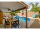 Relaxing poolside patio with wooden dining table and seating at 4636 E Danbury Rd, Phoenix, AZ 85032
