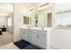 Double vanity bathroom with light gray cabinets and a large mirror at 9567 W Robin Ln, Peoria, AZ 85383