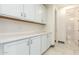 Laundry room with white cabinets and a view into a nearby bathroom at 9567 W Robin Ln, Peoria, AZ 85383