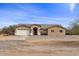 Front view of a single-story house with a two-car garage and desert landscaping at 12121 S 214Th Dr, Buckeye, AZ 85326