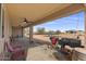 Covered patio with rocking chairs, grill, and backyard view at 12121 S 214Th Ave, Buckeye, AZ 85326