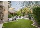 Landscaped backyard with a curved lawn and patio seating at 19501 N 101St St, Scottsdale, AZ 85255