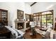 Spacious living room with fireplace, large windows, and access to backyard at 19501 N 101St St, Scottsdale, AZ 85255