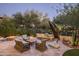 Relaxing patio area with wicker furniture, fire pit, and water feature at 19501 N 101St St, Scottsdale, AZ 85255