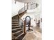 Grand curved staircase with ornate railing and leopard print runner at 19501 N 101St St, Scottsdale, AZ 85255