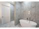 Spa-like bathroom with marble-look tile and a large soaking tub at 26611 S 187Th Ave, Buckeye, AZ 85326