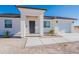 Modern home's exterior features a covered entryway and drought-tolerant landscaping at 26623 S 187Th Ave, Buckeye, AZ 85326