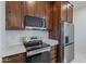 Modern kitchen with stainless steel appliances and dark wood cabinets at 26623 S 187Th Ave, Buckeye, AZ 85326