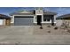 New single-story home with gray exterior, stone accents, and a two-car garage at 35980 W San Ildefanso Ave, Maricopa, AZ 85138