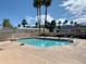 Refreshing community pool with volleyball net, surrounded by palm trees at 614 Ironstone Dr, Apache Junction, AZ 85119