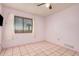 Simple bedroom with tiled floor, window, and ceiling fan at 24906 W Boone Dr, Casa Grande, AZ 85193