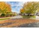 Two-story house with autumn leaves on the ground and a large tree in the front at 3440 N Boulder Ct, Buckeye, AZ 85396