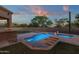 L shaped pool and spa with a relaxing waterfall feature in the backyard at 9325 E Paraiso Dr, Scottsdale, AZ 85255